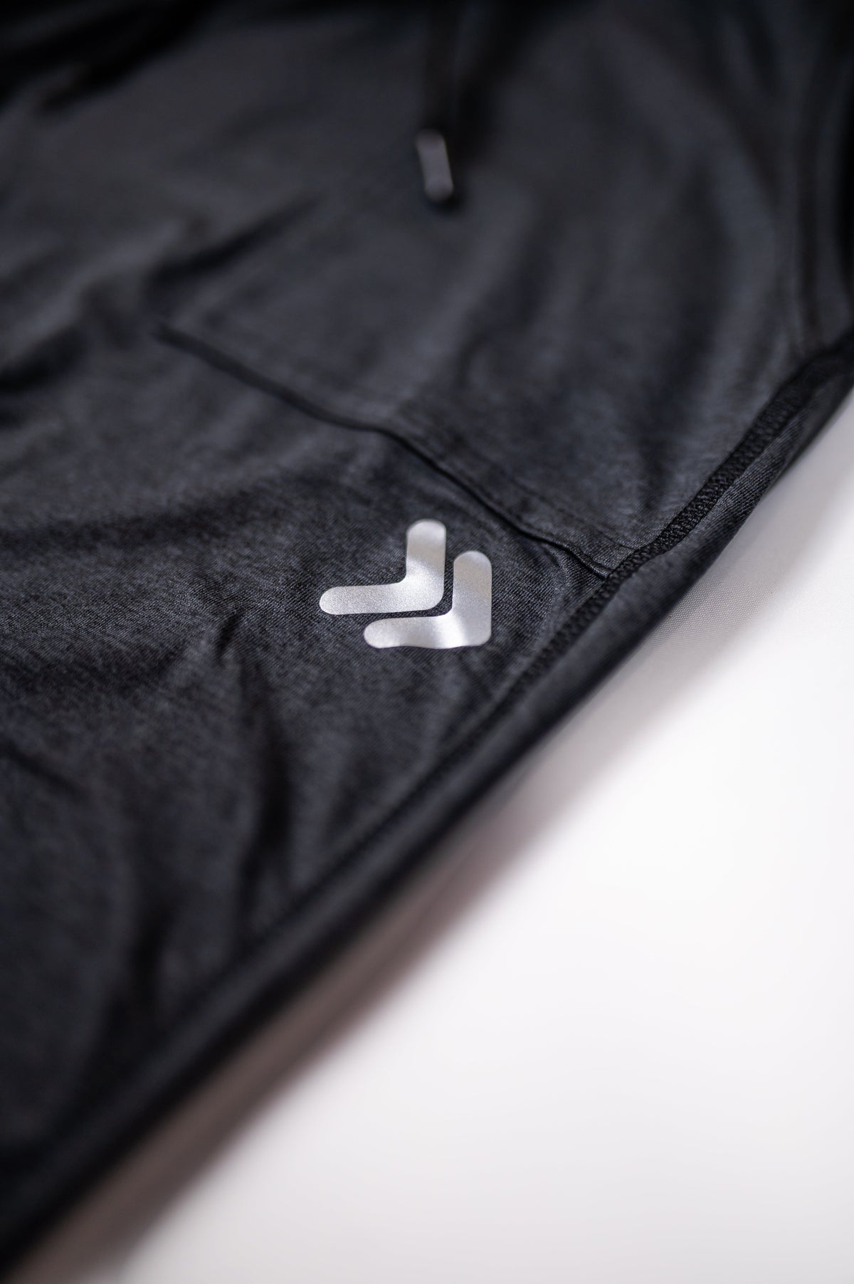 Close-up of the silver 3M reflective double-chevron embellishment on black MOVE Sport Apparel Women’s Essential Joggers.