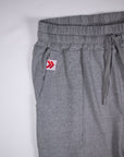 Original white tab with red double chevrons at the grey Essential Joggers pocket opening.
