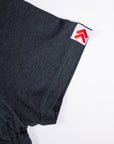 Close-up of the Heather Black MOVE Sport Apparel women’s Essential Short Sleeve sleeve seam and white tag with red MOVE emblem.