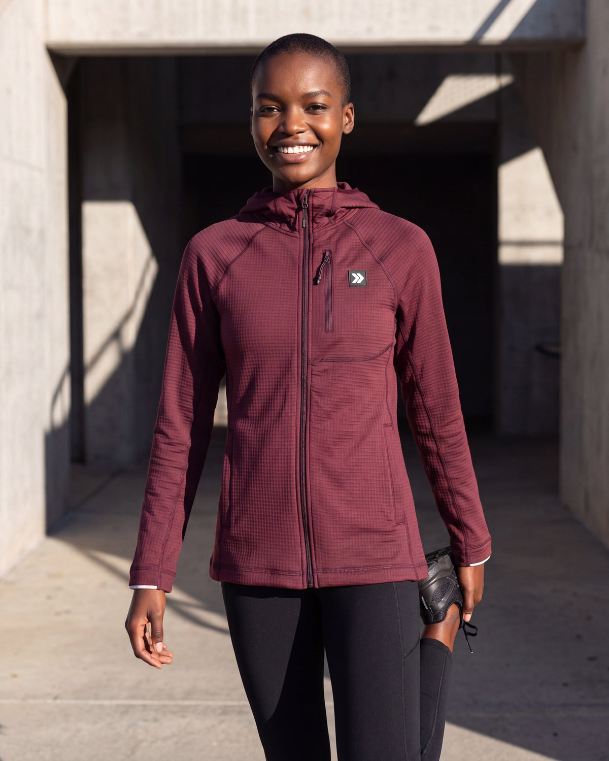 Woman wearing the MOVE Sport Apparel women’s Vineyard Wine Full Zip Waffle Hoodie outdoors.