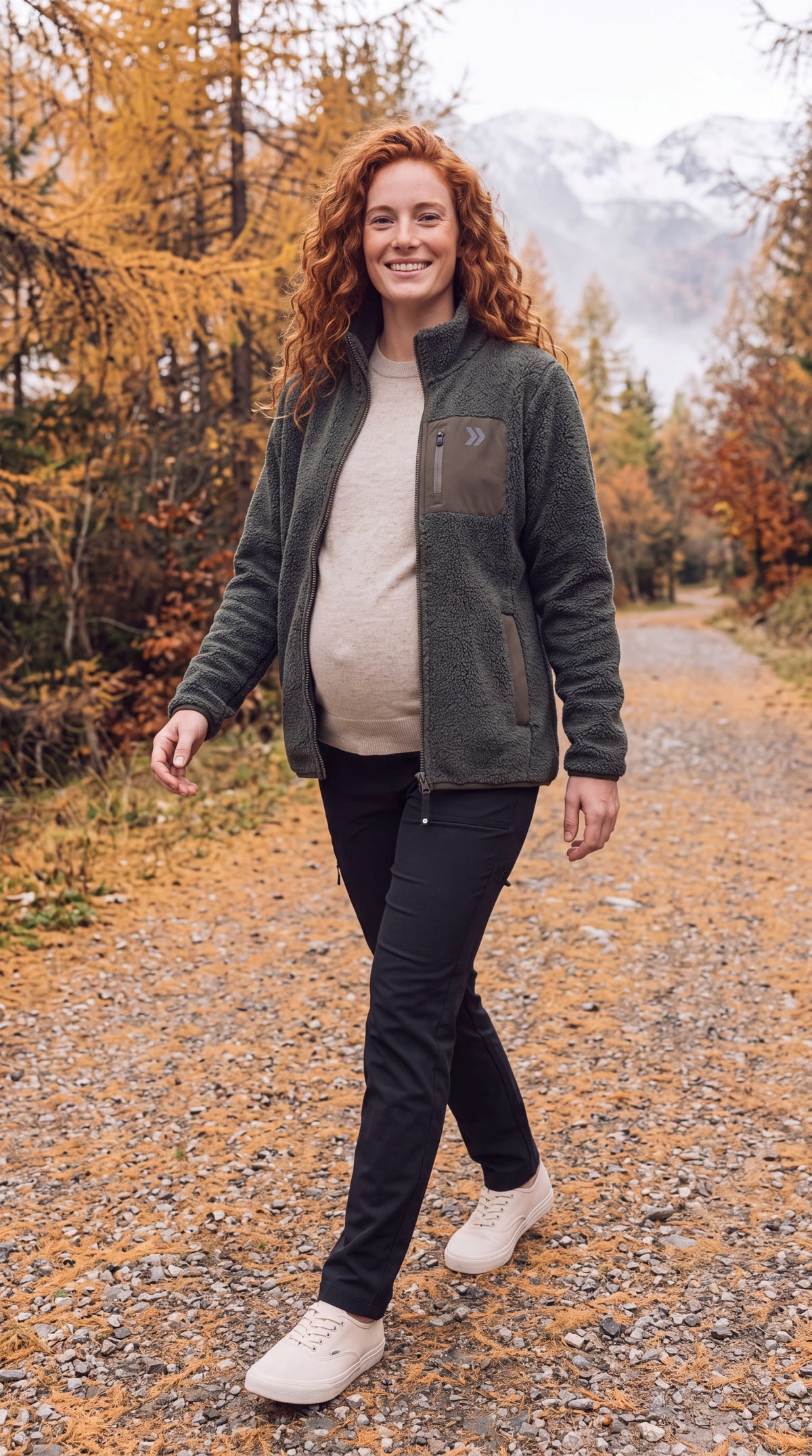 Woman walking on a mountain path among golden autumn trees in the Smokey Olive MOVE Sport Apparel Sherpa jacket.