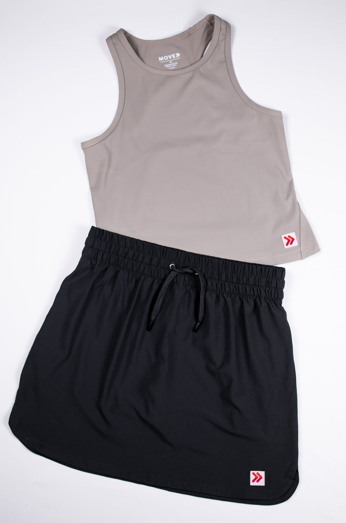 Black MOVE Sport Apparel women’s Skort styled with a taupe sleeveless top in a flat-lay outfit.
