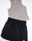 Black MOVE Sport Apparel women’s Skort styled with a taupe sleeveless top in a flat-lay outfit.