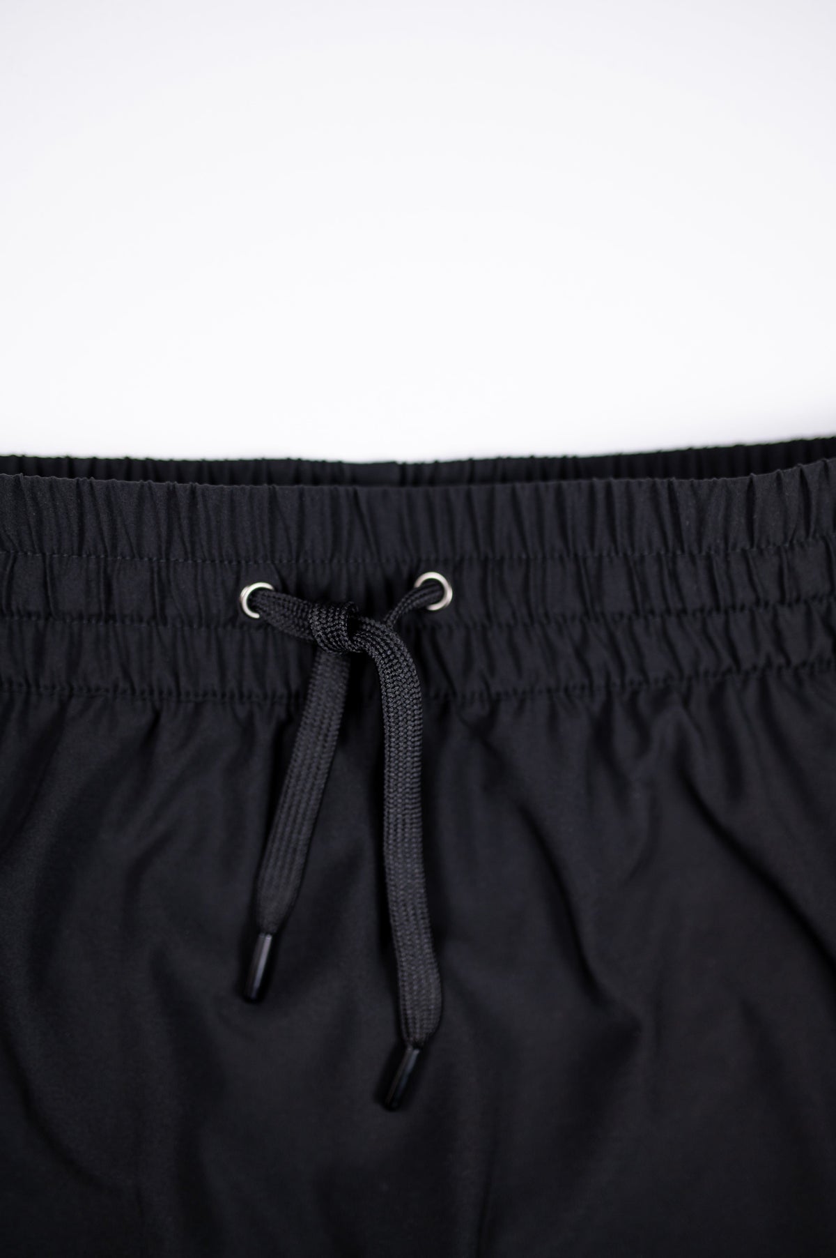 Close-up of black skort waistband stitching, eyelets and drawstring.