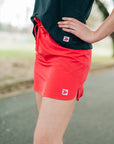 Coral-pink skort and black sleeveless top worn outdoors, showing original hem embellishments.