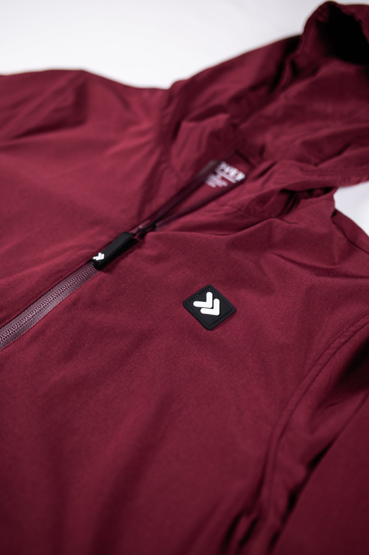 Close-up of the Windsor Wine MOVE Sport Apparel women’s Soft Shell Jacket showing the chest emblem and front zipper.
