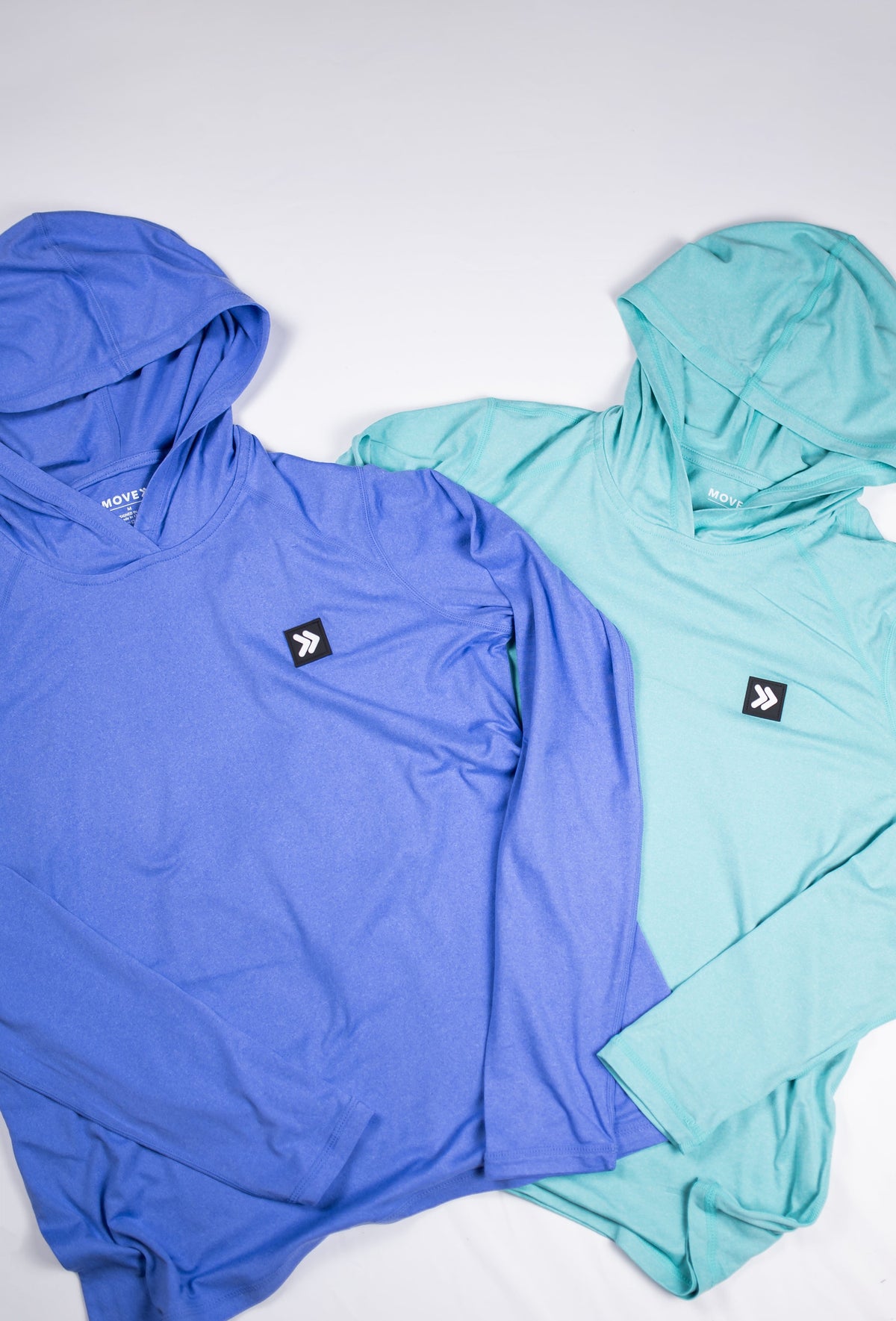 MOVE Sport Apparel women’s Black Label Lightweight Sun Hoodie: Deep Periwinkle and Aqua Splash hoodies shown with their original chest patches.