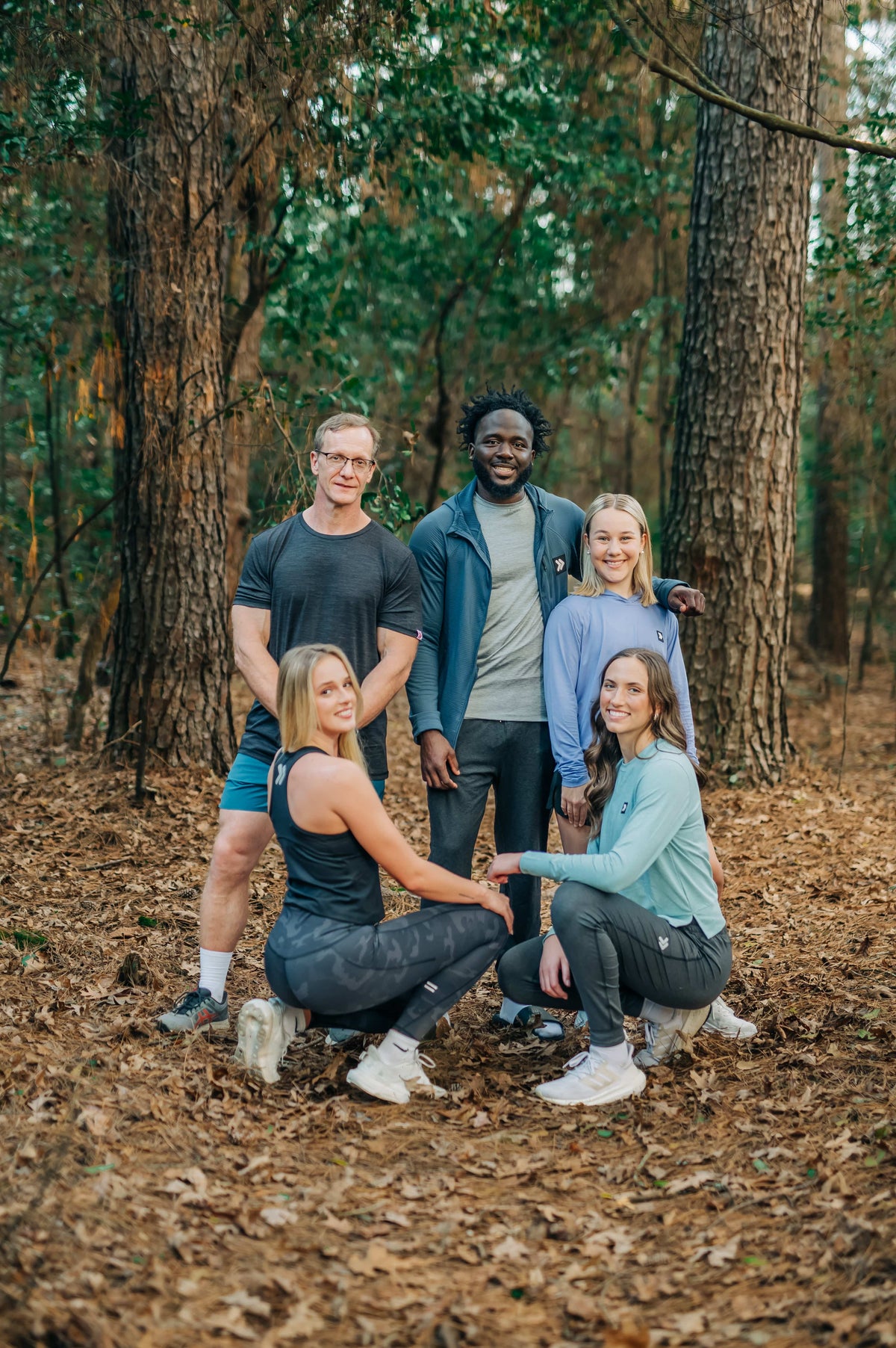MOVE Sport Apparel women’s Black Label Lightweight Sun Hoodie: Group wearing MOVE Sport Apparel outfits in a woodland setting, including the women’s sun hoodie.